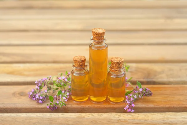 Aceite esencial de tomillo en una hermosa botella en la mesa —  Fotos de Stock