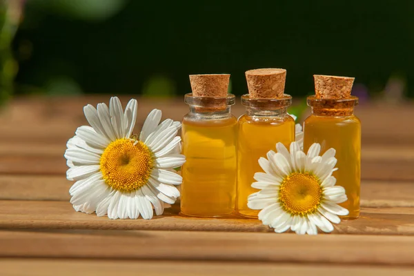 Esencia de flores en la mesa en vidrio hermoso Botella — Foto de Stock