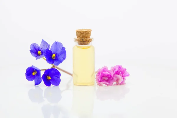 Violet essential oil in  beautiful bottle on White background — Stockfoto