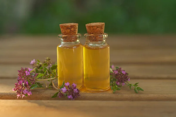 Aceite esencial de tomillo en una hermosa botella en la mesa —  Fotos de Stock