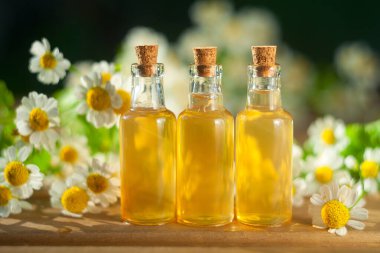 Çiçeklerin özü güzel bir cam şişede masanın üzerinde.