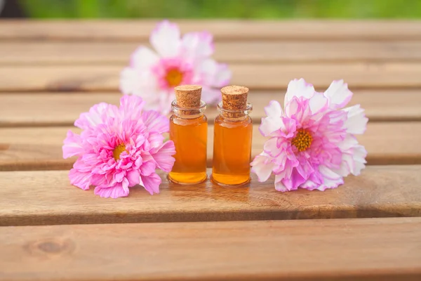 Essence de fleurs sur la table dans une belle bouteille en verre — Photo