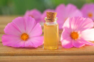 Çiçeklerin özü güzel bir cam şişede masanın üzerinde.