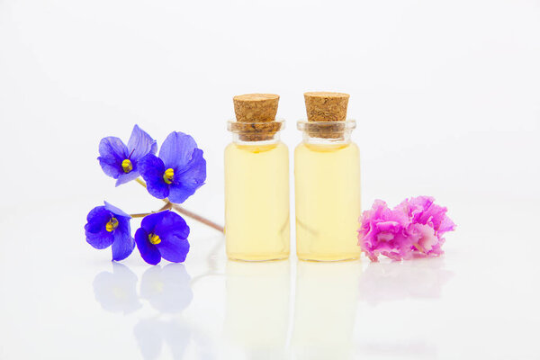 фиолетовое эфирное масло в красивой бутылке на белом фоне
