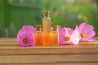 Çiçeklerin özü güzel bir cam şişede masanın üzerinde.