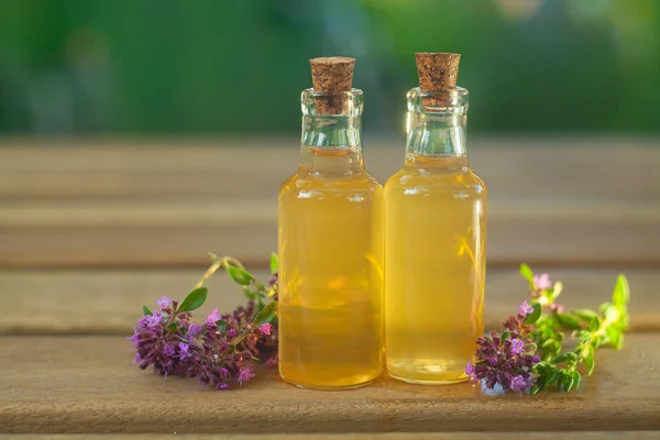 Thyme essential oil in  beautiful bottle on table — Stock Photo, Image