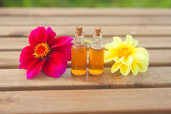 Dahlienätherisches Öl in schöner Flasche auf dem Tisch — Stockfoto