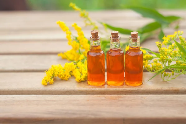 Aceite esencial de varilla de oro en hermosa botella en la mesa — Foto de Stock