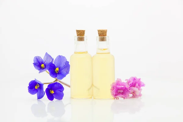 Aceite esencial violeta en hermosa botella sobre fondo blanco — Foto de Stock