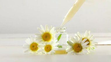 Çiçeklerin özü güzel bir cam şişede masanın üzerinde.