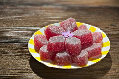 Ahşap bir masada sarı bir tabakta lezzetli meyve reçeli.