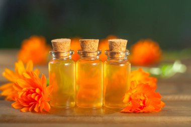 Çiçeklerin özü güzel bir cam şişede masanın üzerinde.