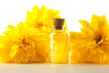 Çiçeklerin özü güzel bir cam şişede masanın üzerinde.