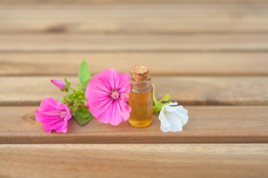 Ahşap arka planda güzel bir şişede mallow yağı.