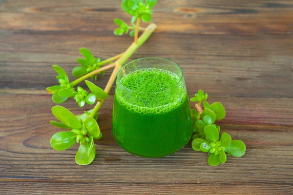 Green herb smoothie on a wooden brown table