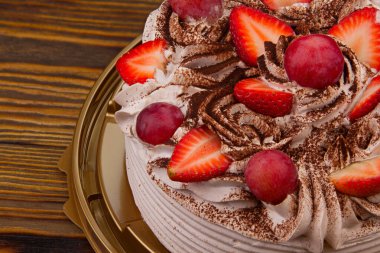 Beyaz arka planda çilek kremalı ve çikolatalı lezzetli bir pasta.