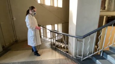 Takım elbiseli bir çalışan enfeksiyon odasını spreyliyor