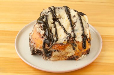 ahşap bir arka plan üzerinde bir tabak üzerinde tarçın ile rulo