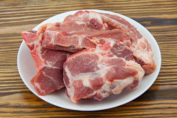 raw red pig meat on a wooden background