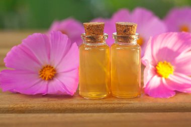 Çiçeklerin özü güzel bir cam şişede masanın üzerinde.