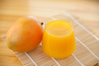 Şeffaf bardakta taze sıkılmış mango suyu.