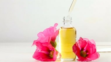 Beyaz arka plan üzerinde güzel şişe de ebegümeci esansiyel yağ