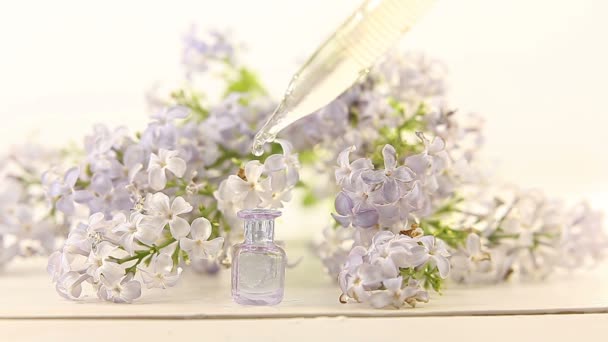 美しいガラスの瓶に白い背景の上に花の本質 — ストック動画