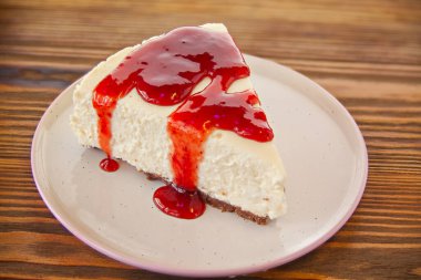 Tabağında çilek olan lezzetli bir peynirli kek.