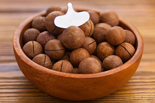 Вкусные Орехи Макадамии Тарелке Деревянном Фоне — стоковое фото