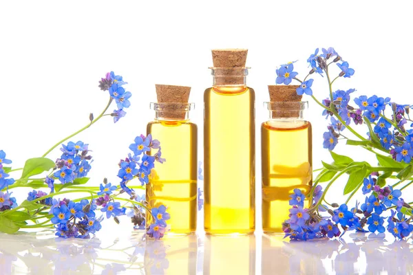 Çiçeklerin özü beyaz bir arka planda güzel bir cam kavanozda