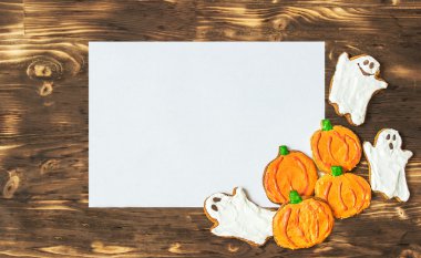 Komik lezzetli ev yapımı zencefilli bisküvi Cadılar Bayramı için koyu ahşap masa ve yetkin levha üzerinde. üstten yatay görünüm