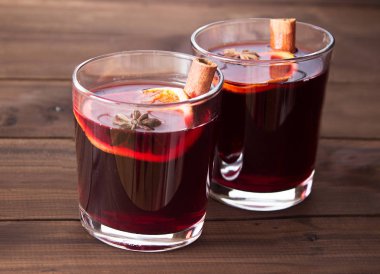 Ahşap arka planda sıcak şarap ve baharatlar.