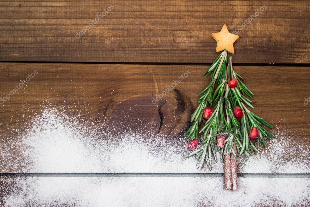 Christmas tree made of rosemary and pomegranate with star-shaped cookie