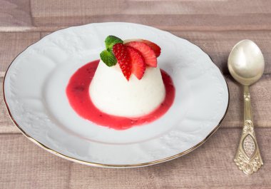 Panna cotta tatlı çilek sirup ve nane yaprağı ile kaşık ile