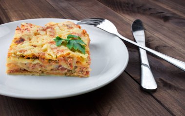 Parskey ile tepesinde bir geleneksel lazanya Close-Up beyaz tabakta servis yapraklar