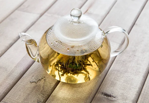 A glass tea pot with Flower Chinese tea on wooden background — Stock Photo, Image