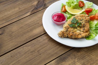 Salata ve meyve sosu ile ev yapımı kotletpane Schnitzel