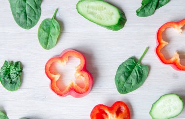 Ispanak yaprakları ve salatalık beyaz zemin üzerine kıyılmış tatlı biber