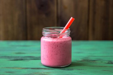 Ahşap arka plan üzerinde bir kavanoza sağlıklı meyve ve meyve güler yüzlü