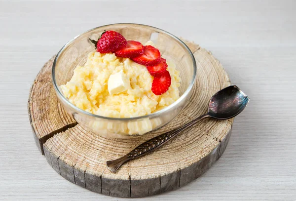 Porridge di mais con fragole - colazione servita su legno segato naturale con cucchiaio vintage — Foto Stock