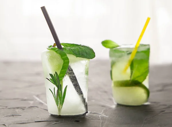 Two glasses with fresh cocktail made of ice on concrete table in front of window — Stock Photo, Image