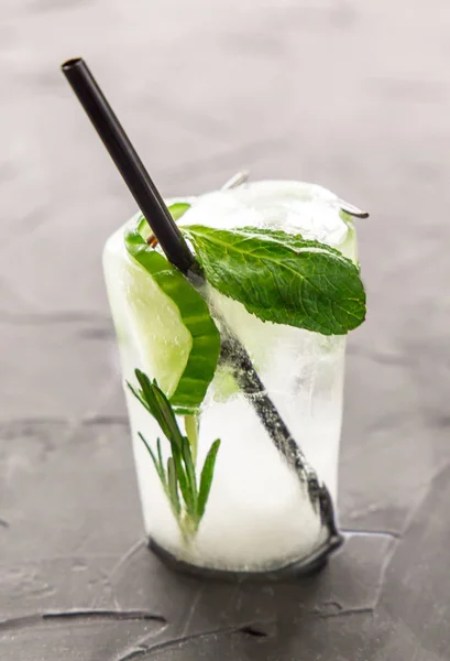 Glass with fresh cocktail made of ice on concrete table — Stock Photo, Image