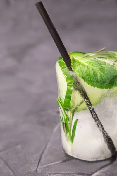 Glass with fresh cocktail made of ice on concrete table — Stock Photo, Image