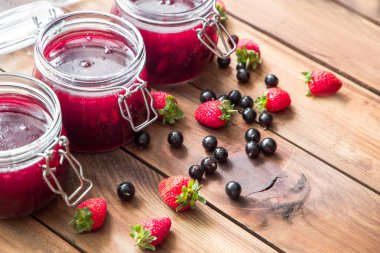 Ahşap masa üzerinde çilek ile ev yapımı reçel