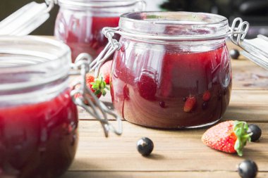 Ahşap masa üzerinde çilek ile ev yapımı reçel