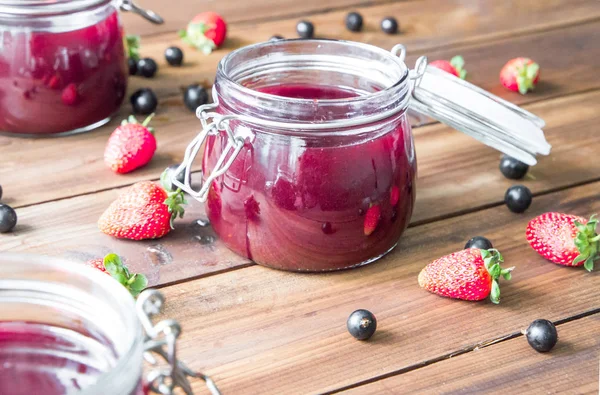 Ahşap masa üzerinde çilek ile ev yapımı reçel