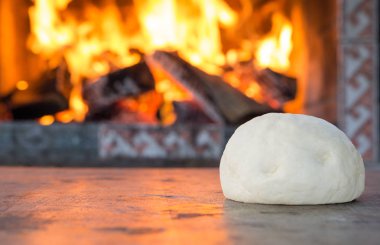 taze çiğ hamur pizza veya yanan şömine karşı ahşap masa üzerinde pişirme ekmek için. konfor ruh kavramı