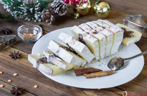 Нарезанный рождественский торт на фоне с праздничными украшениями — стоковое фото