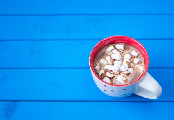 Heiße Schokolade mit Marshmallows isoliert auf blauem Holzgrund. — Stockfoto
