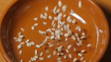 Kahverengi seramik kase düşen bütün pirinç taneleri